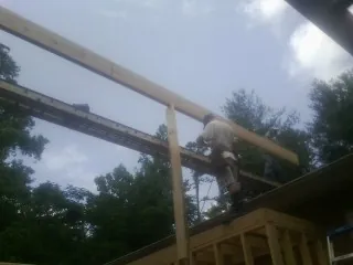 Carpenter setting a ridge beam over a new addition frame — Ice Dam Removal by Roofing Brothers in Wolfeboro